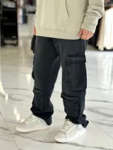 Pantalón de jean estilo cargo, color azul, de corte ancho y holgado, con múltiples bolsillos laterales en muslos y pantorrillas.