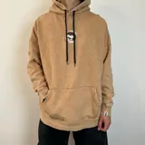Canguro oversize con efecto de lavado ácido en color gris oscuro. Presenta capucha con cordones ajustables, bolsillo frontal tipo canguro y un pequeño estampado circular en el pecho.
