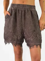 Short de lino color violeta con detalles de encaje bordado en el ruedo.