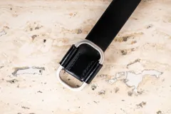 Cinto de cuero negro con hebilla rectangular plateada.