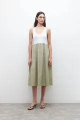 Vestido midi con parte superior blanca tipo musculosa y falda verde con rayas verticales blancas.