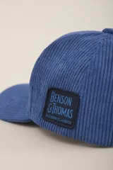 Gorra de pana color petróleo con visera curva y logo de la marca bordado en el lateral.