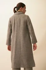 Tapado con cuello solapa y corte recto, color gris. Cierre frontal con botones ocultos, tajos laterales y bolsillos escondidos en corte lateral. Con forro. Tela 100% lana fina sin teñir, diseñada exclusivamente por Don Baez. Hecha 100% en Uruguay.