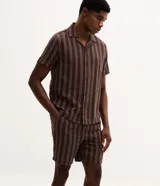 Bermuda masculina confeccionada en tejido jacquard con estampado de rayas texturizadas en color marrón. Posee cintura elástica con cordón ajustable y bolsillos laterales.
