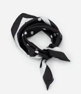 Pañuelo cuadrado de satén con estampado de lunares blancos sobre fondo negro. Accesorio versátil de tejido fluido, ideal para usar en el cuello, el cabello o como detalle en bolsos.