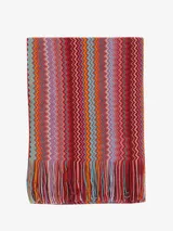 Chal o bufanda de tejido de punto con patrón de zigzag multicolor en franjas verticales, con flecos en los bordes.