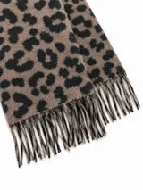 Bufanda con estampado animal print tipo leopardo en tonos marrón y negro, terminada con flecos en los extremos.