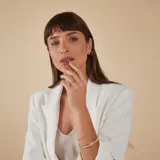 Esclava rígida de oro 18k con acabado satinado y diseño de cinta plana. Presenta una textura fina en su superficie y un diseño minimalista.
