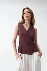 Chaleco cruzado sin mangas, color bordó, con escote en V y lazo ajustable en la cintura.