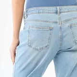 Jeans de maternidad con corte mom, de tiro alto y color azul claro. Presenta un diseño clásico con costuras visibles y terminación de botamanga deshilachada.