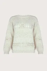 Suéter de punto calado color beige, de corte holgado y caída natural. Presenta un cuello redondo y mangas largas, ligeramente abullonadas, con detalles de calado y bordes festoneados.