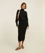 Suéter de manga larga confeccionado en tricot, con cuello alto y diseño de bordado de rombos en relieve. Presenta puños y ruedo acanalados.