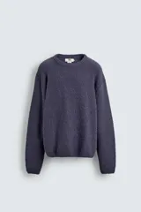 Jersey de hombre de corte relajado, color azul oscuro o morado apagado, con textura rizada (bouclé) y cuello redondo.