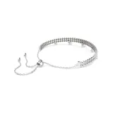 Pulsera plateada con doble hilera de cristales Swarovski y perlas colgantes. Cierre ajustable con bola deslizante.