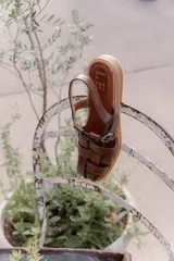 Sandalias tipo huarache de cuero con diseño de tiras entrelazadas, punta cerrada y cierre con hebilla lateral. Cuentan con suela plana y plantilla con logo grabado.