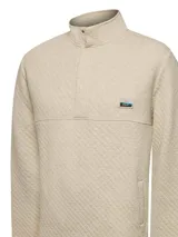 Buzo de hombre con diseño acolchado de rombos, cuello alto con cierre de broches y manga larga. Presenta un parche decorativo en el pecho y bolsillos frontales.