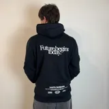 Canguro color caqui con capucha y cordón ajustable. Estampado en la espalda con la frase "The essence of living life fully and energetically", el logo "vibrant journeys", la frase "live for the present" y una cita de Santa Barbara.