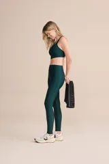 Top deportivo de compresión media con diseño de espalda cruzada y breteles finos. Confeccionado en tejido acanalado con un acabado de brillo sutil, cuenta con copas removibles y tecnología de ajuste adaptable.