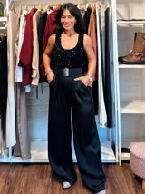 Musculosa negra sin mangas, confeccionada en terciopelo con aplicación integral de lentejuelas brillantes. Presenta un escote redondo y un corte ajustado al cuerpo.