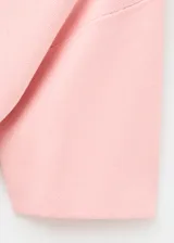 Jersey de punto color rosado, con cuello alto, manga corta y diseño recto.