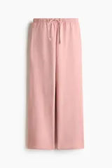 Jogging rosado de felpa con cintura elástica y cordón ajustable, de corte holgado y piernas amplias con bolsillos laterales.