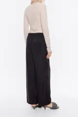 Pantalón negro de lino, estilo jogger, con largo tobillero, cintura fruncida con cordones y bolsillos laterales con vivo.