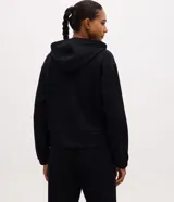 Campera deportiva de corte regular confeccionada en modal, con cierre frontal por cremallera, capucha con cordón ajustable, mangas largas con puños elásticos y bolsillos laterales.