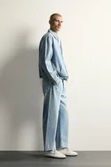 Jeans de corte regular cropped confeccionados en denim ligero de algodón. Presentan un diseño de cinco bolsillos con efecto lavado, tiro medio y cierre frontal con botones.