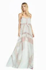 Vestido largo de corte fluido confeccionado en chiffon color verde agua, con diseño strapless y detalle de lazo frontal. Presenta paneles verticales de encaje en tono beige que recorren la prenda, aportando textura y un estilo romántico.