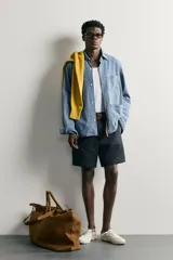 Bermuda regular fit azul marino confeccionada en lino, con bolsillos frontales, bolsillos traseros de doble vivo con botón y cierre frontal con cremallera y botón.