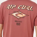 Remera de manga corta color bordó con cuello redondo. Presenta un pequeño estampado gráfico en el pecho con el logo de la marca y la inscripción 'Born at Bells 1969'.