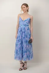 Vestido midi de tul plisado con estampado floral en tonos celestes y violetas, tirantes finos y detalle drapeado tipo corsé en el cuerpo.