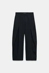 Pantalón de tiro medio con diseño wide leg, confeccionado en tejido con viscosa. Presenta un patrón de rayas diplomáticas, bolsillos laterales ocultos y detalle de pinzas pronunciadas en el delantero. Cierre frontal con cremallera, botón y ganchos metálicos.