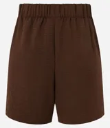 Short de mujer confeccionado en tejido airflow, caracterizado por su textura arrugada intencional. Presenta cintura elástica y bolsillos delanteros, ofreciendo un calce liviano y cómodo.