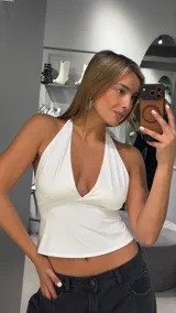 Top halter blanco con escote en V profundo y corte acampanado.