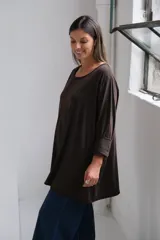 Remera de algodón color chocolate, de corte holgado y diseño oversize, con cuello redondo y mangas tres cuartos con terminación desflecada.