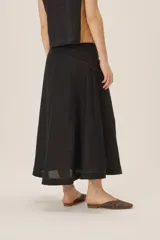 Falda midi color bordó con brillo sutil y detalle de lazo en la cintura.