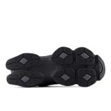 Championes urbanos New Balance modelo 9060, color negro con detalles en gris oscuro. Presentan un diseño robusto y futurista inspirado en la estética Y2K, confeccionados con parte superior de malla y superposiciones de gamuza, entresuela gruesa con amortiguación y suela texturizada.
