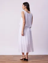 Vestido largo blanco de crepe con escote redondo y detalle de crochet en los hombros. Tiene corte en la cintura con punto smock.