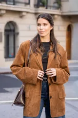 Blazer de corte oversize en color marrón, con diseño estructurado, cuello clásico, cierre frontal de tres botones y bolsillos laterales con solapa.