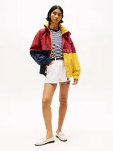 Campera de nailon con diseño color block en rojo, amarillo y azul marino. Tiene cuello alto, cierre de cremallera oculto con botones a presión, puños y bajo elásticos, dos bolsillos ribeteados en la cintura y logo de Tommy Hilfiger en la parte delantera, la trasera y las mangas.