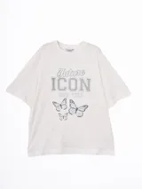 Remera de corte oversize color crema, con cuello redondo y mangas cortas. Presenta un estampado frontal con la frase 'Future Icon New York' y un diseño de mariposas en tonos azulados.