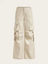 Pantalón cargo color crema de corte baggy, con múltiples bolsillos en los laterales y aberturas en los tobillos.