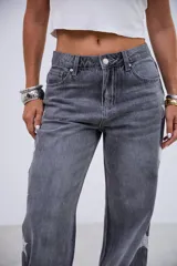 Jean de corte recto y tiro medio-bajo, color gris lavado, con detalle de estrellas bordadas a lo largo de los laterales externos de las piernas.