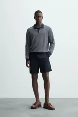 Bermuda de hombre color beige claro, corte regular fit, con pliegues frontales, bolsillos delanteros y bolsillos traseros de doble vivo con botón.