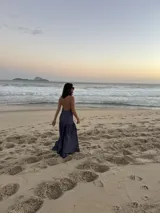 Vestido largo marrón de crepe texturizado, con cuello halter fruncido, diseño holgado y falda larga con vuelo.
