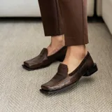 Mocasines de cuero vacuno color marrón con diseño reptil, punta cuadrada y taco de madera foliado de 2,5 cm.