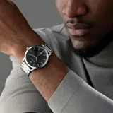 Reloj Emporio Armani modelo Ruggero con caja de acero plateado de 43mm y esfera negra con indicadores plateados. La correa es de acero inoxidable plateado. Resistente a salpicaduras (3 ATM).