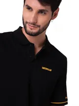 Chomba Caterpillar de hombre color negro, con cuello polo y cierre frontal de dos botones. Cuenta con detalles de líneas amarillas en los bordes de las mangas cortas y el logo de la marca estampado en amarillo en el pecho.