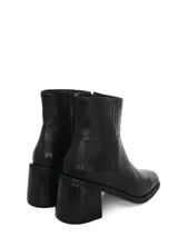 Botín de cuero negro con caña media, taco cuadrado y punta cuadrada. Cuenta con cierre lateral interno para facilitar el acceso.